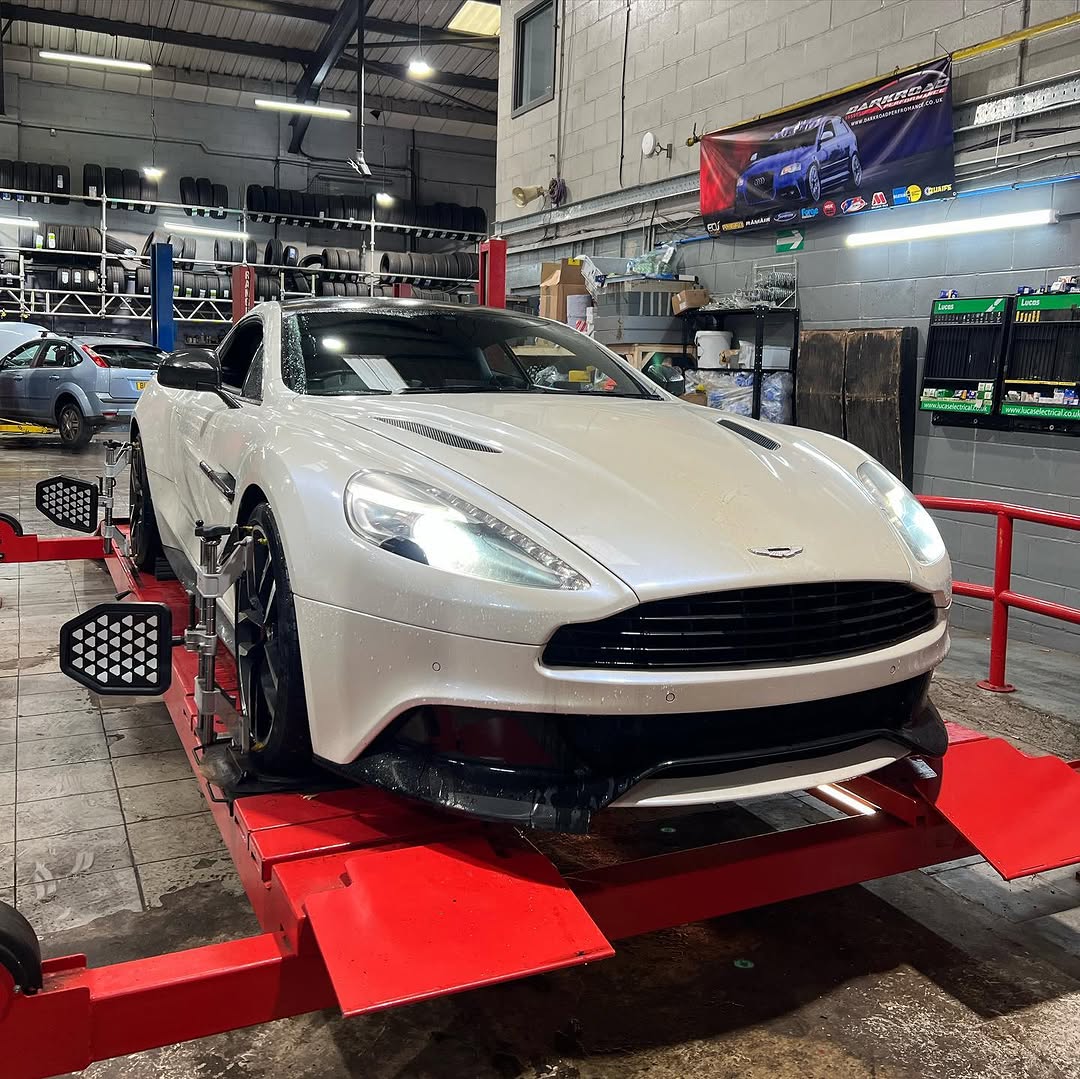 A white Aston Martin on the alignment rig